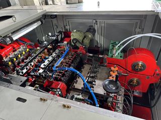 Open forming area of a Chun Zu CBF series bolt former showing the die stations, red drive housings and coolant lines